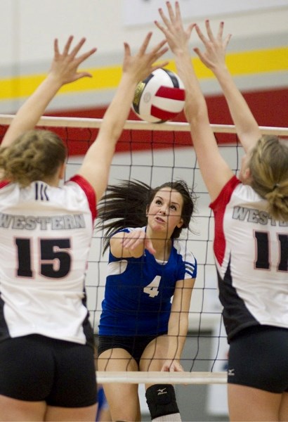 Maddi Agius of the Paul Kane Blues tries to punch the ball through the defensive blocking tandem of Sylvie Rokosh (left) and Susan Thompson of the Western Canada Redmen