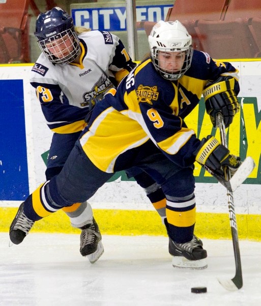 Sabrina Flemming of the St. Albert Slash skates away with the puck from Averyl Toews of the Grande Prairie Storm during second period action Sunday at Performance Arena. In