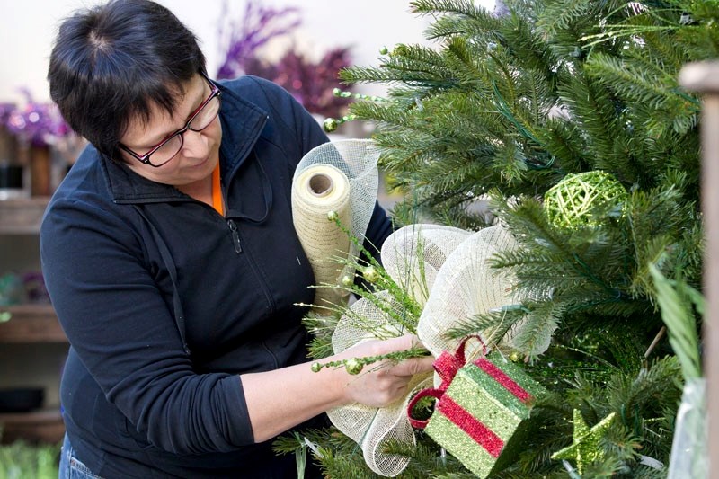 Lesleah Horvat of the Enjoy Centre demonstrates how Sinamay ribbons can change the look of a Christmas tree.