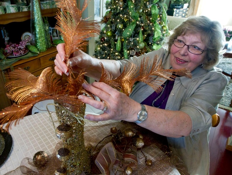 Irene Hill puts the finishing touches on a table centrepiece built around a mesh vase in the shape of a high-heeled boot.