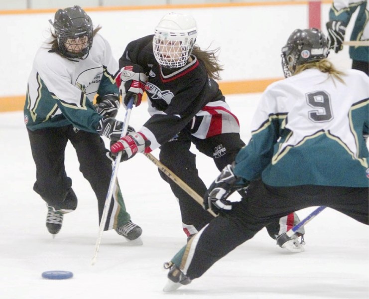 St. Albert SWAG forward Jordynne Hogan splits the Spruce Grove Core defence during the Zone 5 round-robin qualifier for the 2012 Alberta Winter Games on Thursday night.