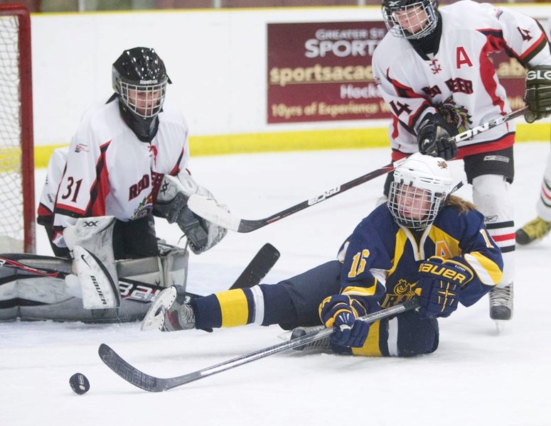 EXTRA EFFORT &#8211; Kyrelle Skoye of the St. Albert Female Raiders attempts to get a shot away from a sitting position against Red Deer Chiefs&#8217; netminder Alexandra