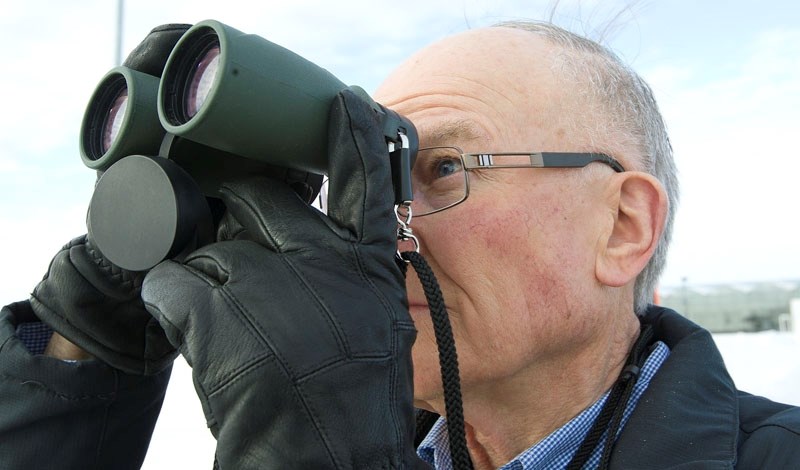 AVID BIRDER – St. Albert resident Mike Pich keeps his binoculars trained on a snowy owl perched on a streetlight along Riel Drive during the annual St. Albert Christmas Bird