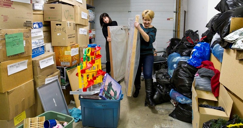SPACE CRUNCH – Lo-Se-Ca Foundation director Marie Renaud (left) and staff member Sharon McRae-Baker move some donated paintings out of the back of the organization&#8217;s