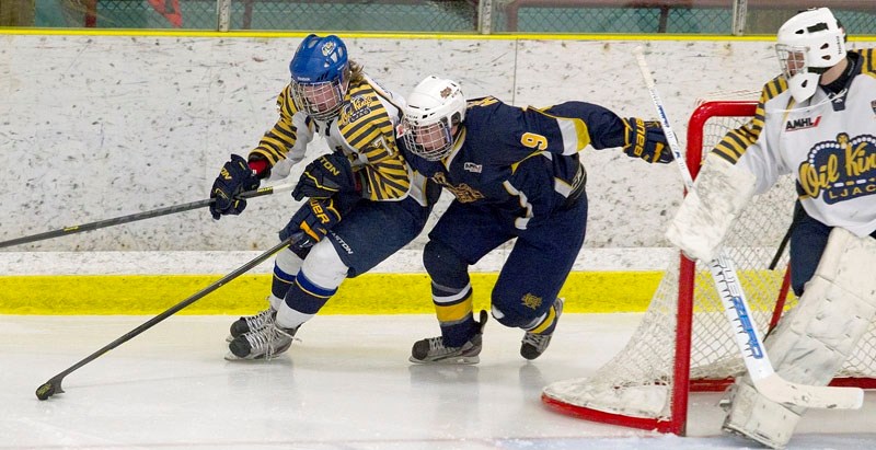 TIED UP &#8211; Dan Huculak of the St. Albert Raiders tries to work the puck around the net while covered by Graydon Smith of the Leduc Oil Kings in Wednesday&#8217;s midget