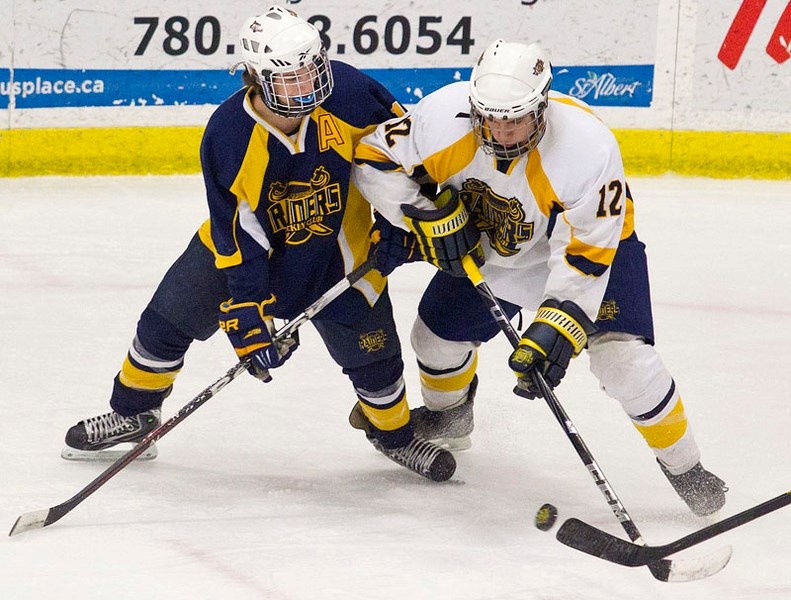 MIDGET AA SHOWDOWN &#8211; Steven Canduro (left) of the St. Albert Blues jostles with Jesse Letourneau of the St. Albert Crusaders in Friday&#8217;s midget AA game at