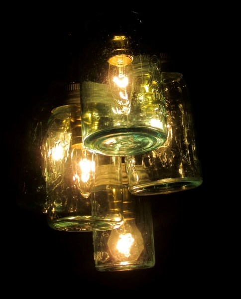 CREATIVE JUICE – This homemade light fixture encloses bare bulbs in old jars purchased at an antique sale.