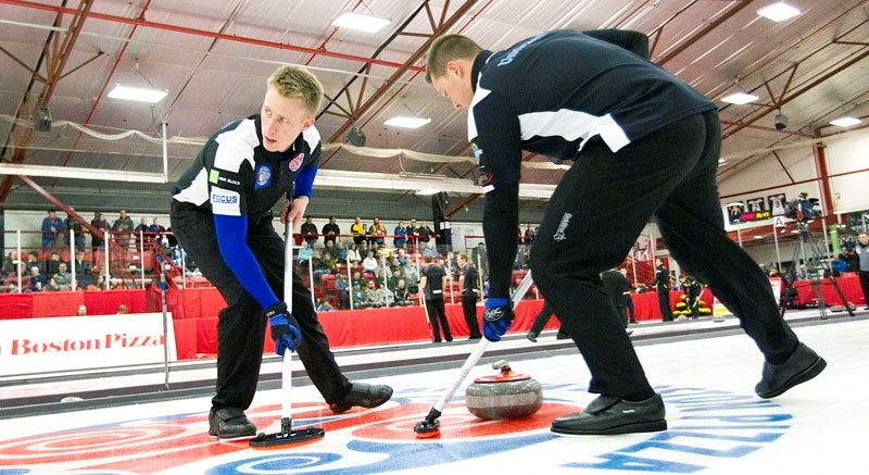 SMOOTH AS ICE &#8211; The front-end tandem of Marc Kennedy of St. Albert and Ben Hebert sweep a rock for the Kevin Martin rink at the Boston Pizza Cup provincial men&#8217;s