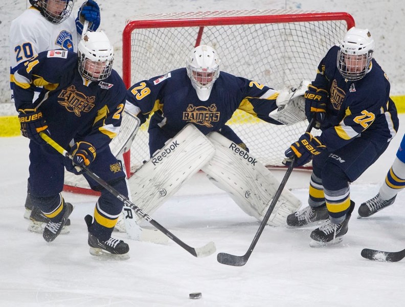 TEAMWORK – St. Albert Raiders defencemen Jake Kohlhauser (left) and Zack Gonek help clear the puck away in front of netminder Mitch Martell in Sunday&#8217;s midget AAA game
