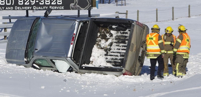 SLIPPIN&#8217; AND SLIDIN&#8217; – St. Albert Fire fighters discuss how to winch an overturned pick-up truck out of a ditch north of St. &amp;lt;br /&amp;gt;Albert. Strong