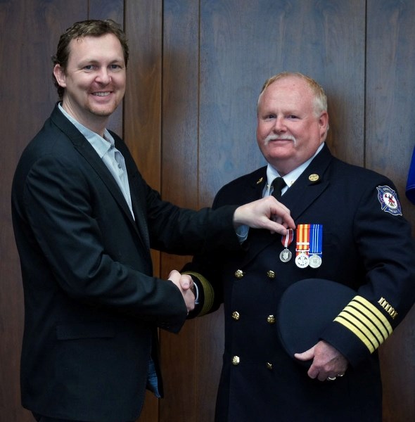 GROWING COLLECTION – Morinville Fire Chief Ron Cust gets his Diamond Jubilee Medal from Municipal Affairs Minister Doug Griffiths.