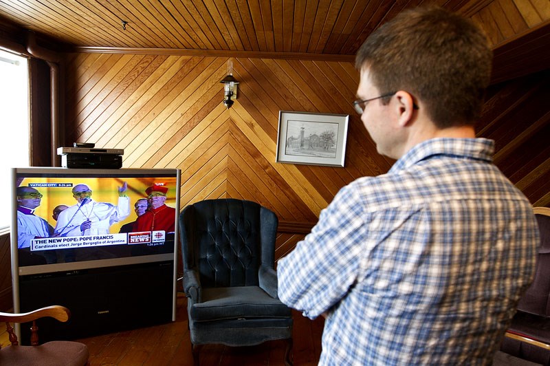 PONDERING THE PONTIFF – Father Ken Thorson takes a moment to catch up on the announcement of Pope Francis as the new leader of the Catholic church on Wednesday afternoon.
