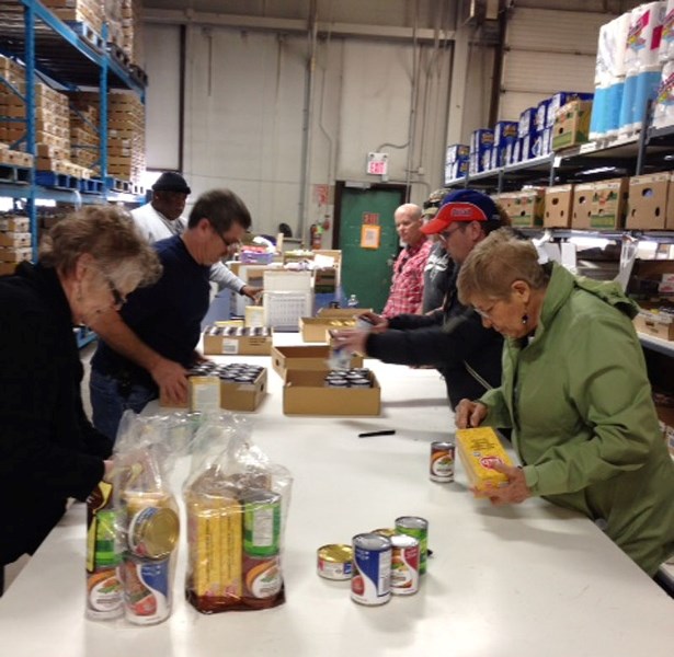 SORTING IT OUT – A group of clients from the Glenrose Rehabilitation Hospital&#8217;s Adult Active Living program do some volunteer sorting at the St. Albert Food Bank last