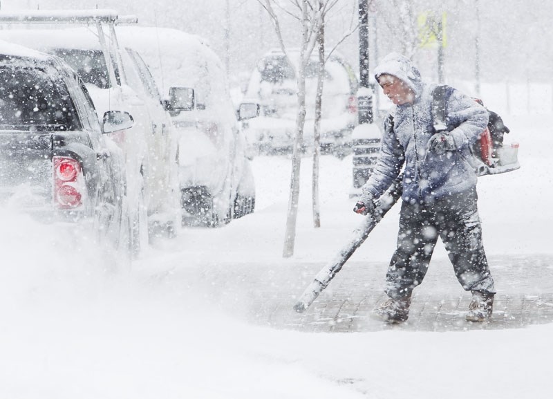 BLOWING SNOW –Bernie Bourgeois of The Rock Salon and Spa clears his sidewalk as a massive snowstorm continues to rage on Thursday. When it was over
