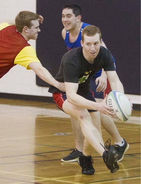 HAVING A BALL &#8211; Josh Elliott busts a move against Luc Saulnier (left) and Dylan Corcoran during the St. Albert men&#8217;s rugby training session Sunday at Paul Kane