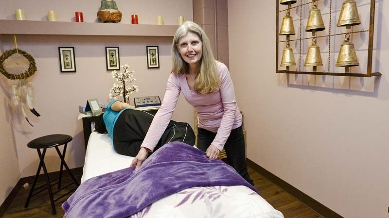 COMMUNITY VILLAGE – Community liaison Fay Lucy gets a client ready in one of the new wellness rooms at the St. Albert Food Bank&#8217;s Community Village. Run by a social