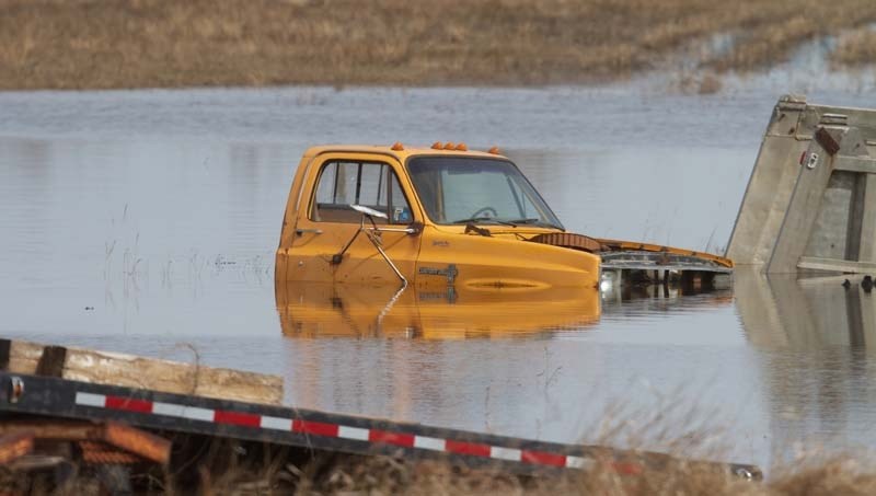 WATERLOGGED &#8211; A farm truck sits partially underwater in a low lying field on Highway 37.