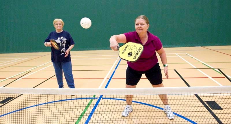 ON THE BACKHAND – Celine D&#8217;aoust (left) and Nicole Currie play a game of pickleball at Servus Credit Union Place. The pair is new to the game.