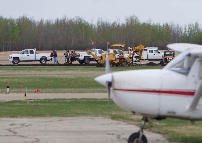 BREAK TIME – Construction workers take a break from expanding the runway at Villeneuve Airport on Monday.