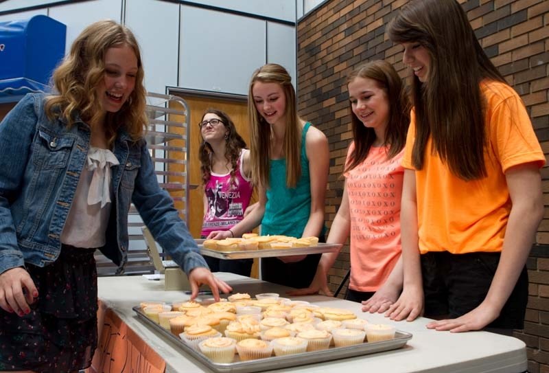 SOCIAL CAKES – Andrea Payne (right) and Corissa Tymafichuk (second from right) sell cupcakes to students at Paul Kane High School. They were raising money and awareness for