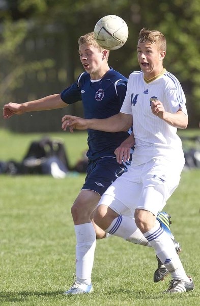 PASS IT ON – St. Albert Impact (Rochat) Spencer Burchett #14 moves the ball during a game against Scottish United (in blue) at Poplar field behind ESSMY School Saturday late