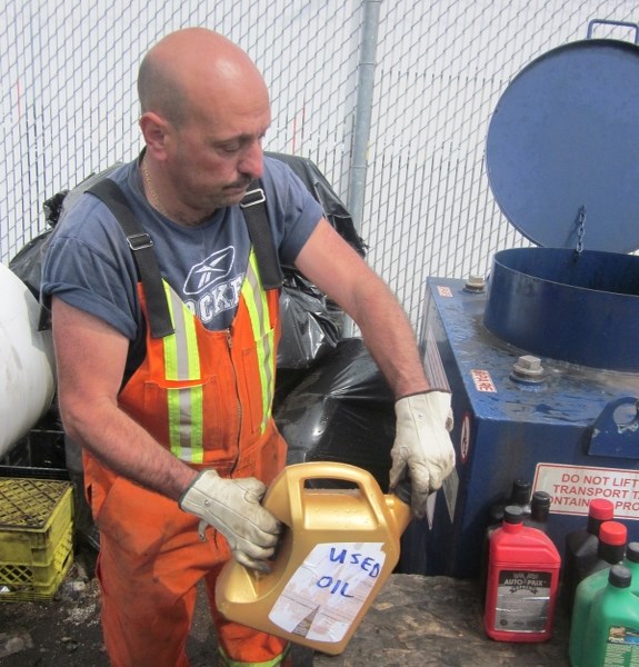 OIL&#8217;S WELL THAT ENDS WELL – City of St. Albert refuse operator Santo Roppo pours used oil into a recycle bin at the Campbell Park recycling centre Thursday. A new
