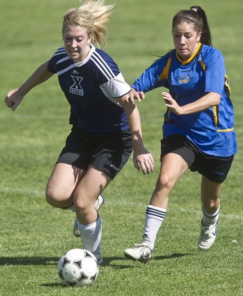 SOCCER SHOWDOWN &#8211; Charity Price of the St. Albert Skyhawks pressures Kelsey Salpeter of the St. Francis Xavier Rams for the ball in Tuesday&#8217;s metro Edmonton high