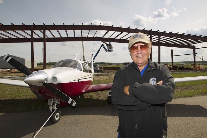 WINGS UP – Eldon Gjesdal stands in front of a new type of internally rotating hangar under construction at Villeneuve airport. Gjesdal predicts the airport could become home