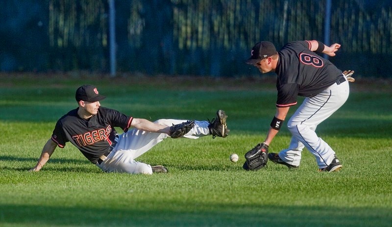 PLAYING CATCH &#8211; Darren Adams (left) and Brandon Barr of the senior AAA St. Albert Tigers scramble to make the catch in the outfield in Tuesday&#8217;s 5-3 loss to the