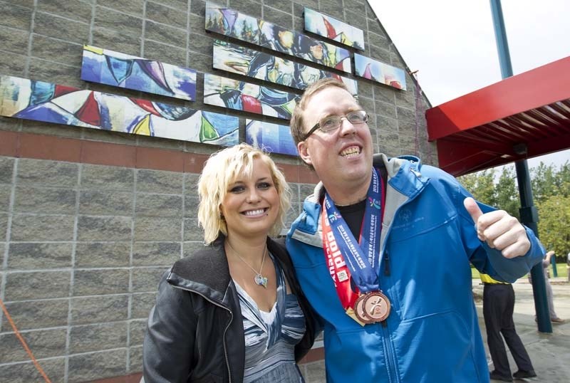 GOLD STANDARD – Artist Samantha Williams-Chapelsky and Special Olympics athlete Larry Green unveil Flags at the Finish Line Friday afternoon at Kingswood Park.