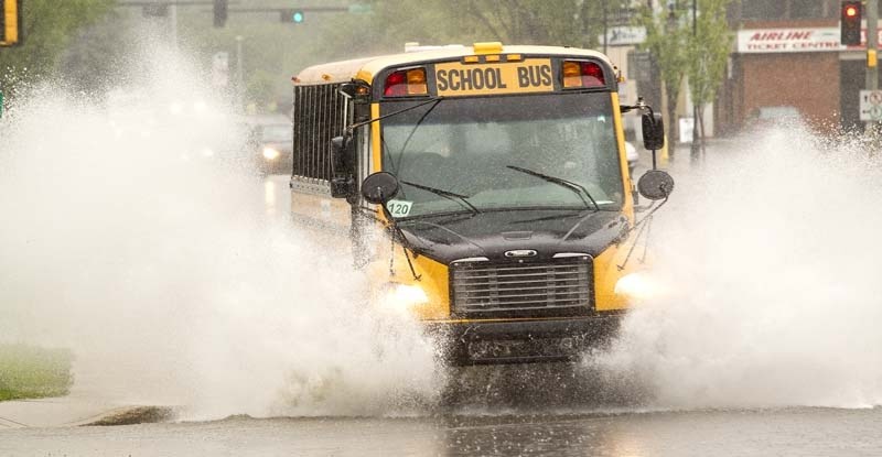 WET RIDE – A school bus drives through a huge puddle along Sturgeon Road near St. Albert Trail during Tuesday&#8217;s heavy rain.