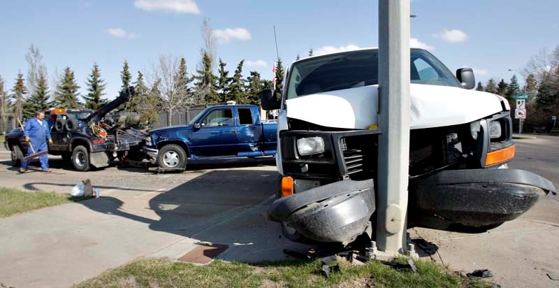 CROSSROADS CONCERN – A tow truck driver cleans up the scene of a three vehicle collision at the intersection of Levasseur Road and Gervais Road/170 Street. Three quarters of