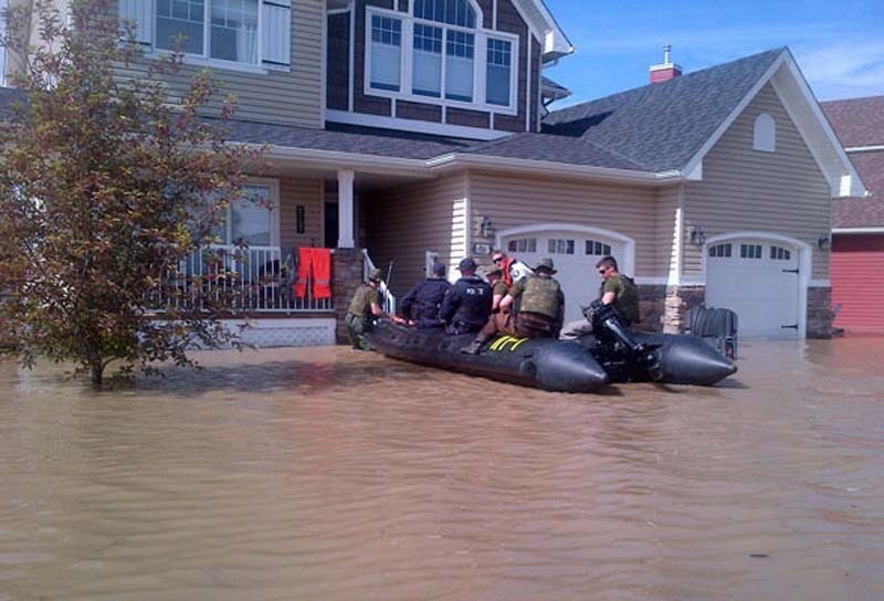 AT YOUR SERVICE – Members of the RCMP and the Canadian Forces provide disaster relief to flood-stricken parts of southern Alberta.