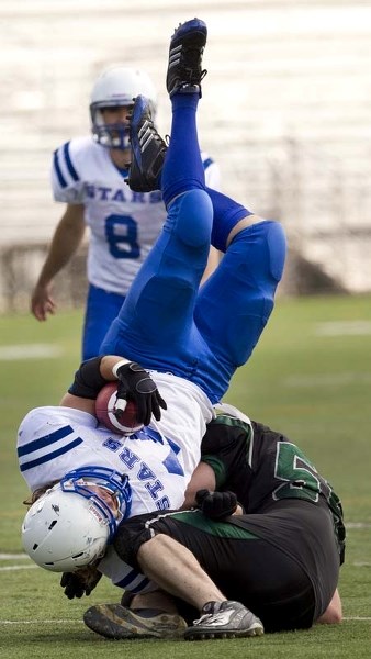 FALLING STAR – St. Albert Stars runningback Mike Goldring tumbles over a Lloydminster Vandal Saturday at Clarke Park. The Vandals pounded the Gators 79-3.