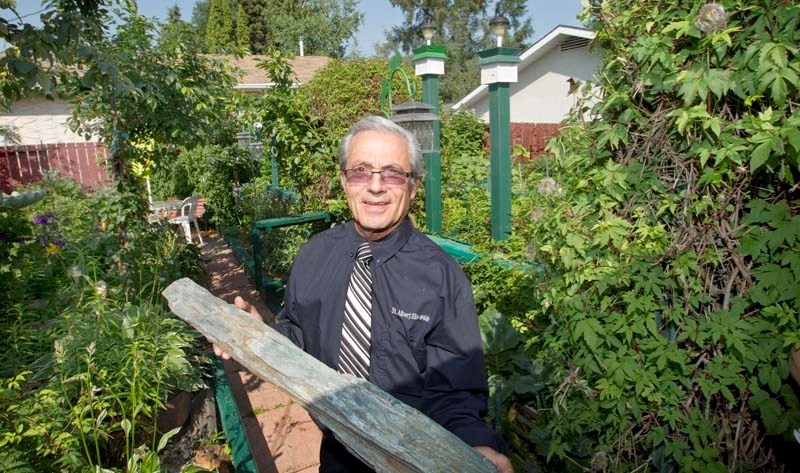 GARDEN LOVER – Tony Foddis shows off a piece of petrified wood that he displays in his backyard