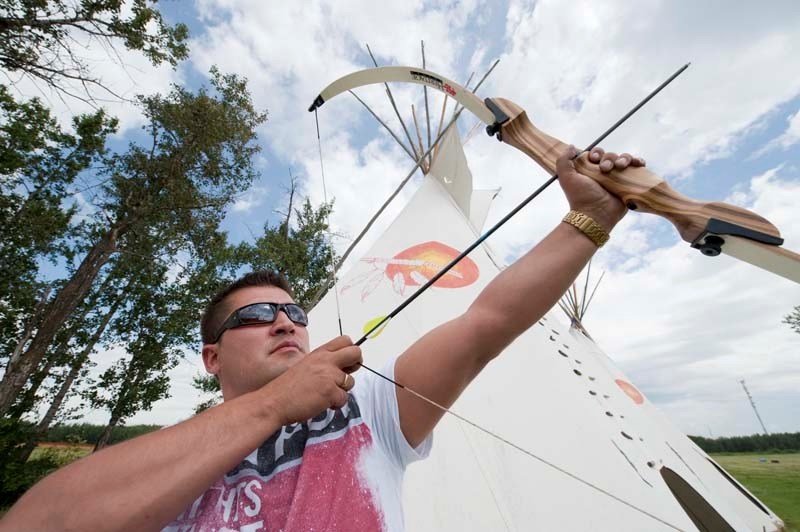 TAKING AIM — Alberta Indigenous Games volunteer Cody Stephen demonstrates the use of the bow on the Poundmaker&#8217;s Lodge powwow grounds. The grounds will be the site of