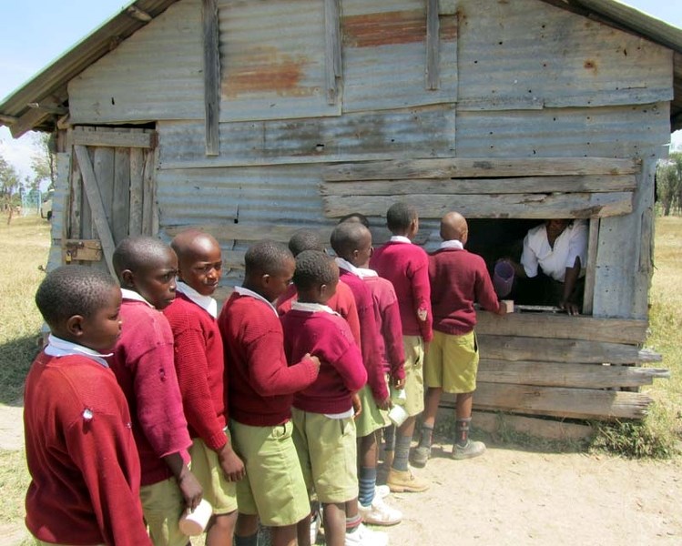 BREAKFAST TIME – School children line up for their daily ration of porridge