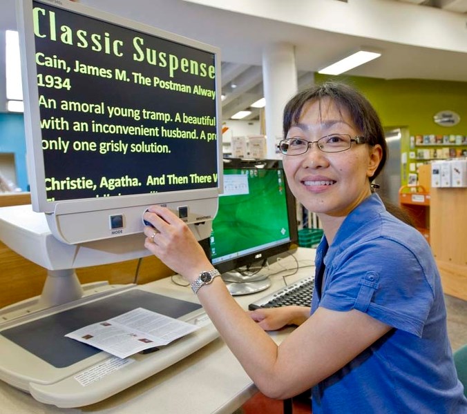 MAKING IT BIG – Special services co-ordinator Janice Cheung demonstrates the library&#8217;s magnifying machine