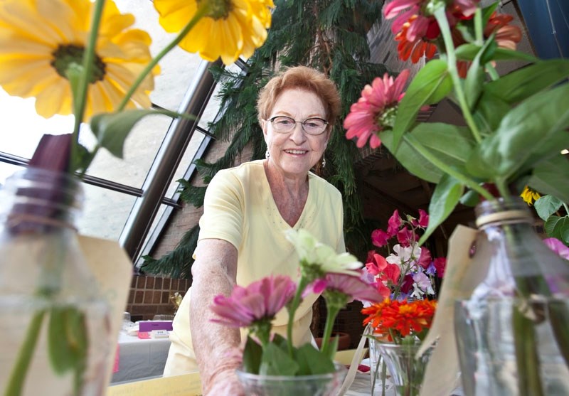 St. Albert garden club member Ireen Slater makes sure all the awrded ribbons are just right on the top flowers at the 31st annual flower show at St. Albert Place on Sunday.