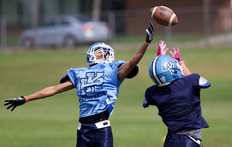 GRIDIRON BLUES &#8211; Frankie White plays the ball on a pass to Ryan Strachan at the Paul Kane Blues&#8217; fall camp Monday. The first Miles conference game for Paul Kane