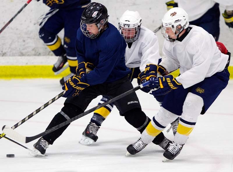 MIDGET AAA TRYOUTS &#8211; Sean Richards guards the puck against two defenders at the St. Albert Raiders&#8217; intersquad game last weekend at Akinsdale Arena. The Raiders