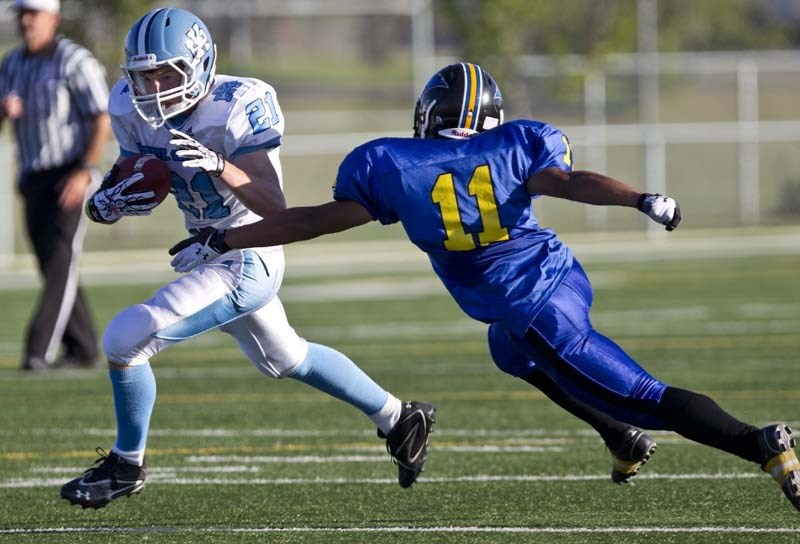 PLAYMAKER &#8211; Theo Block of the Paul Kane Blues breaks away from Jienco Uchman of the St. Albert High Skyhawks en route to the endzone in the Battle of St. Albert on