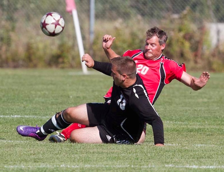 PLAYOFF CHALLENGE &#8211; Danny Bruha of the Rummies sticks his tackle to knock the ball away from Brandon Kinley of GSE in the St. Albert Men&#8217;s Soccer League final