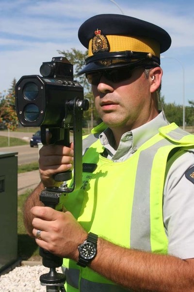 SLOW DOWN – St. Albert RCMP Cst. Jaden Courtney conducts laser speed control outside J.J. Nearing school earlier this month.