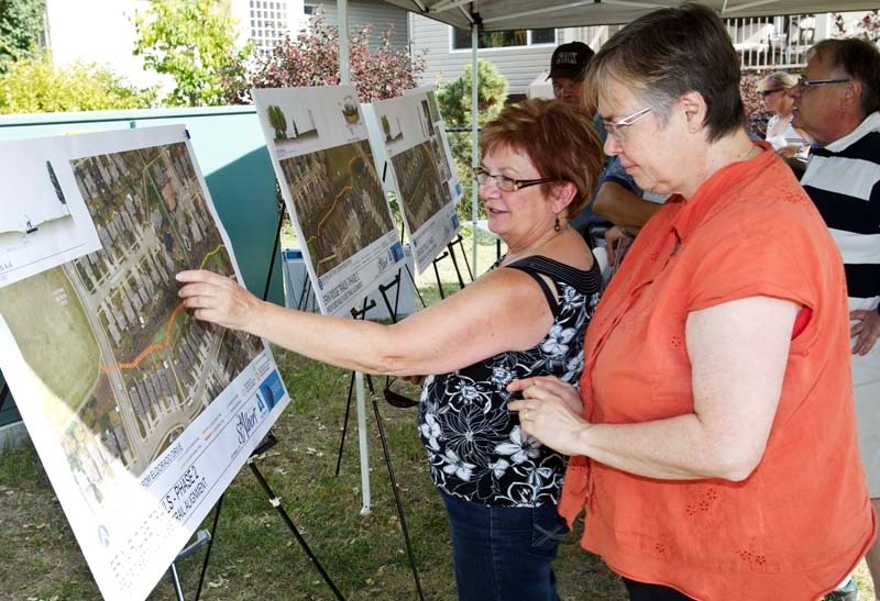 MAPPED OUT – Solange Phelps (left) and Theresa Tomaszewski check out the trail system proposed for their Erin Ridge neighbourhood on Saturday during an information open house.