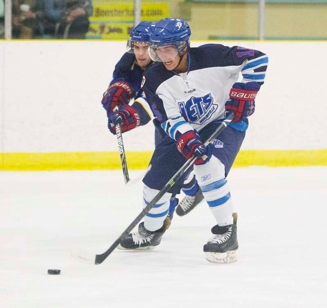 BREAKING AWAY &#8211; Karmen Ward of the St. Albert Merchants attempts to slow down Brandon Domoslai of the Morinville Jets in Friday&#8217;s junior B season opener at