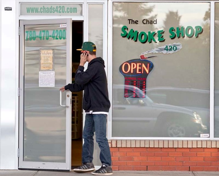 CHAD&#8217;S PLACE – A young male talks on a cellphone while walking into The Chad Smoke Shop Tuesday evening in Gateway Village Mall on Hebert Road.