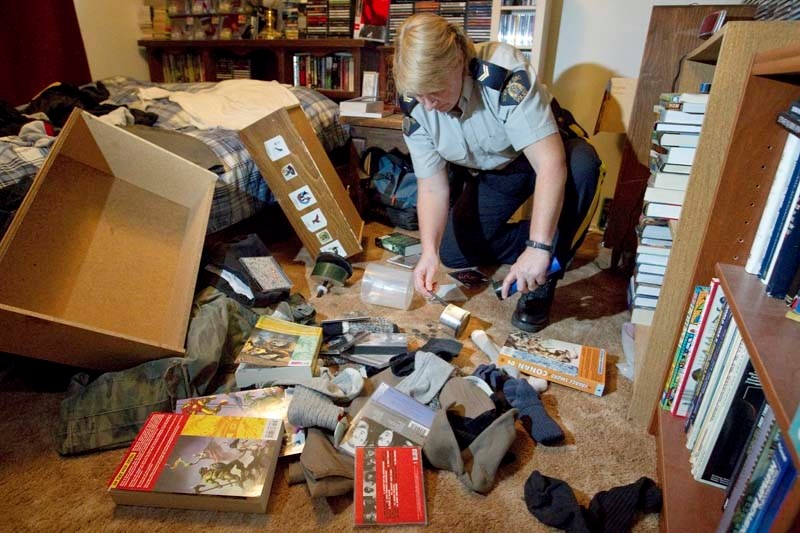 BIG MESS – Cpl. Laurel Kading looks for evidence as she sifts through items left strewn about during a mock break-in exercise at Gazette editor Stu Salkeld&#8217;s home.