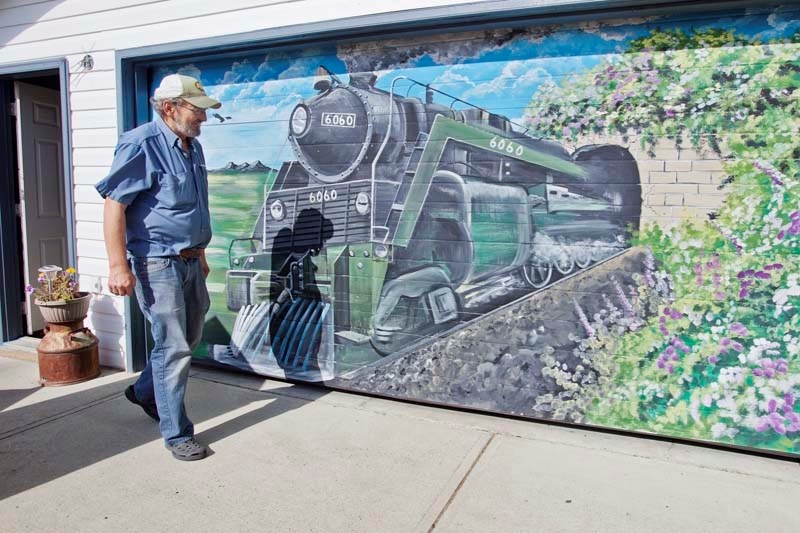 Morinville resident Frank Koenig takes a good look at the new mural adorning his garage door thanks to the brush and artistic vision of St. Albert artist Rob Murray who