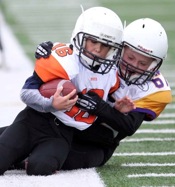 ATOM SHOWDOWN &#8211; Tristen Olenick of the St. Albert Buccaneers is tackled along the sideline by Alexander Lessard of the St. Albert Vikings in Sunday&#8217;s atom Tier